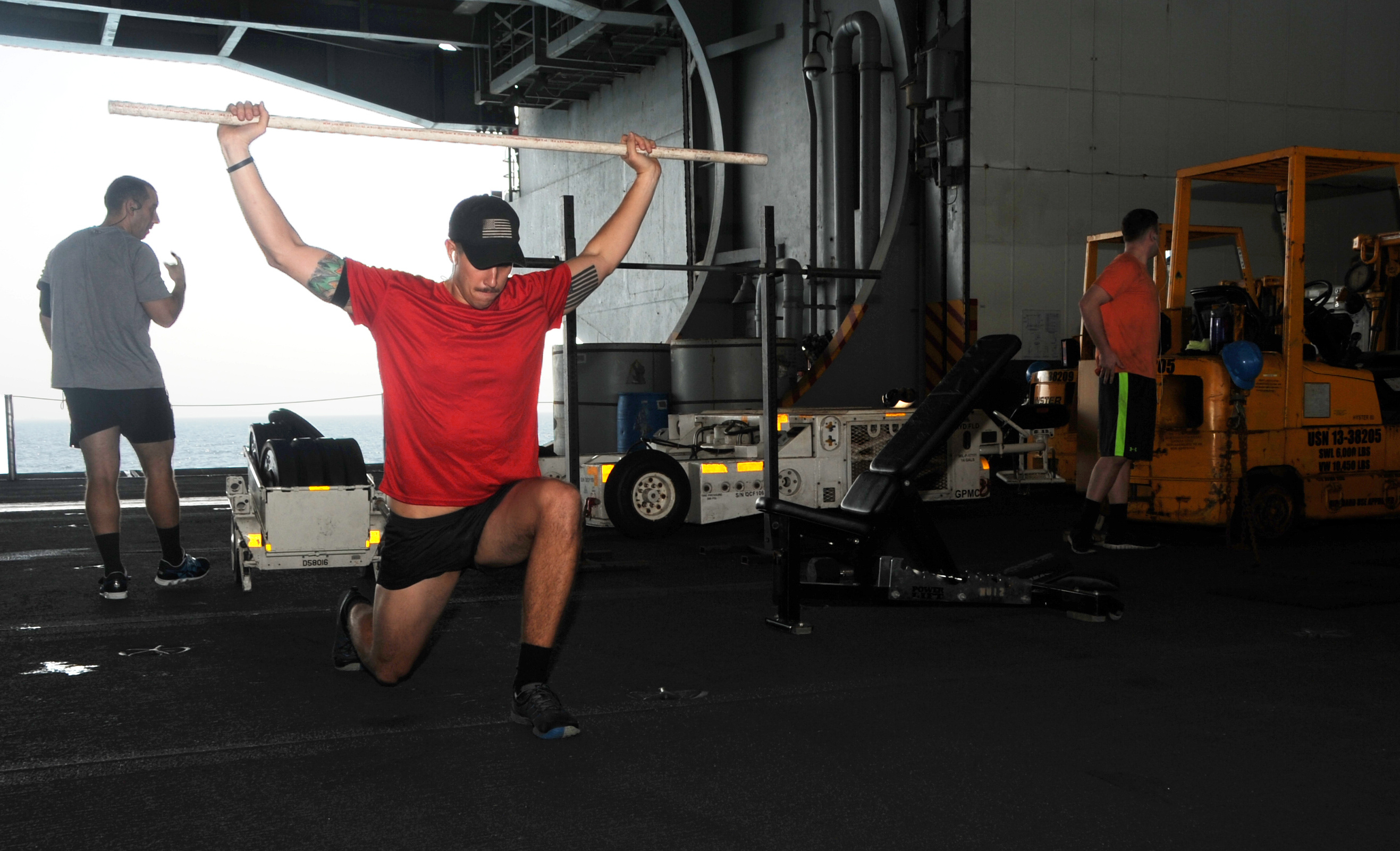 man lunging with a bar held over head