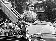 Adolf Hitler standing in his car as he travels through Nuremberg to open the Nazi Congress, 6 September 1938